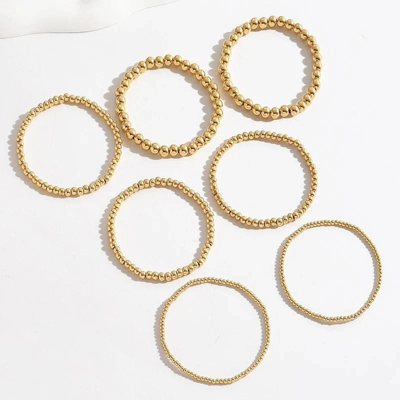 Set de 7 pulseras doradas de cuentas apilables