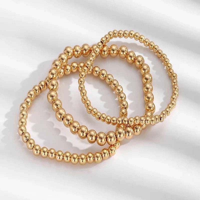 Set de 7 pulseras doradas de cuentas apilables