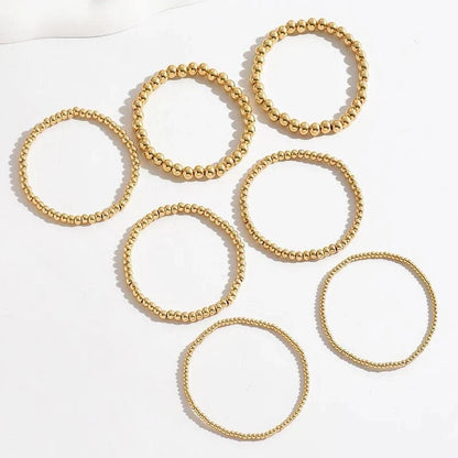 Set de 7 pulseras doradas de cuentas apilables