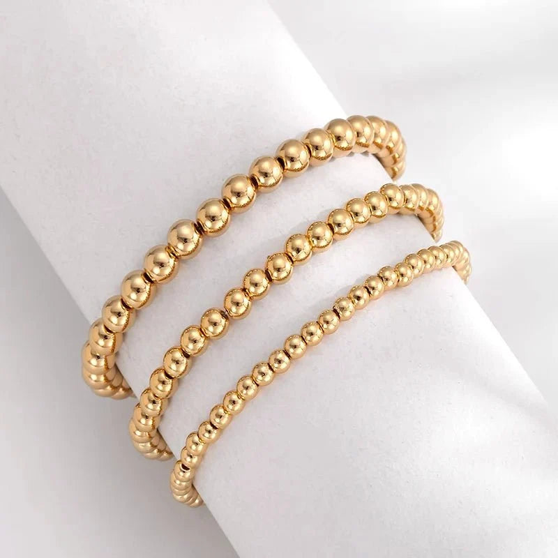 Set de 7 pulseras doradas de cuentas apilables