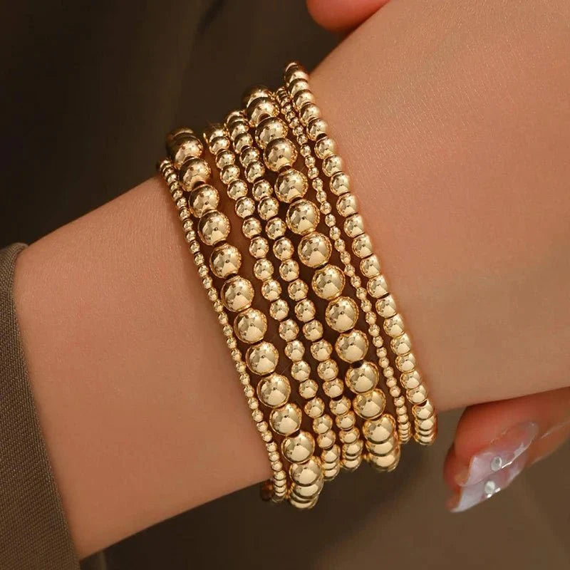 Set de 7 pulseras doradas de cuentas apilables