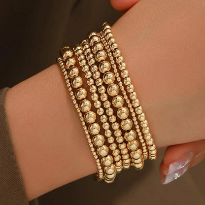 Set de 7 pulseras doradas de cuentas apilables