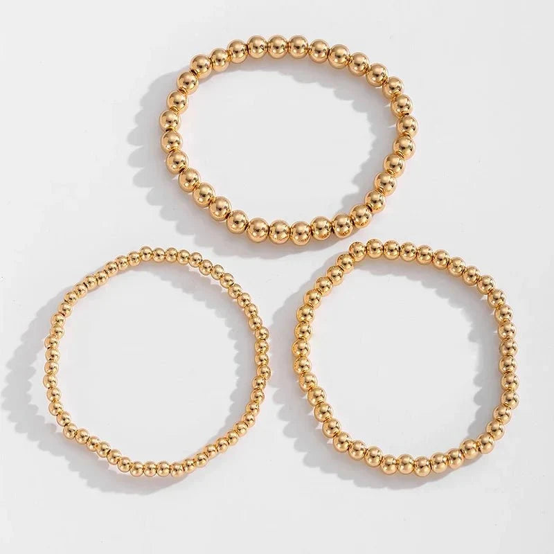 Set de 7 pulseras doradas de cuentas apilables